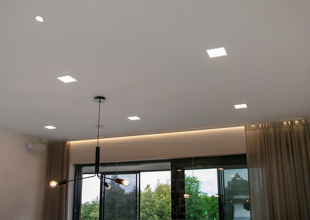 Recessed panel lights creating general lighting in the living room. Atmospheric, hotel-style indirect lighting above the windows. The groove was left wide enough to accommodate a curtain track.